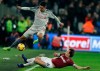 Liverpool's Roberto Firmino, left, and West Ham's Mark Noble challenge for the ball during the English Premier League soccer match between West Ham United and Liverpool at the London Stadium in London, Monday, Feb. 4, 2019.(AP Photo/Kirsty Wigglesworth)