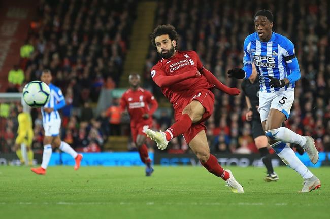 Liverpool's Mohamed Salah shoots on goal during the English Premier League soccer match between Liverpool and Huddersfield Town at Anfield Stadium, in Liverpool, England, Friday, April 26, 2019.(AP Photo/Jon Super)