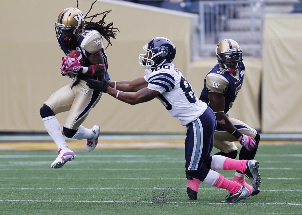 The Canadian Press files
Winnipeg Blue Bombers' Alex Suber (21) snags the pass in front of Toronto Argonauts' Romby Bryant (80) during a 2013 game in Winnipeg. Suber is heading to Toronto in exchange for Argos defensive lineman Thaddeus Gibson.