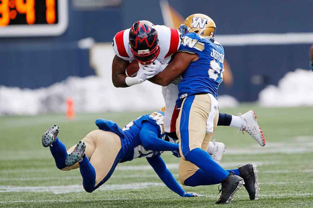 JOHN WOODS / THE CANADIAN PRESS
Winnipeg Blue Bombers' Jackson Jeffcoat (94) and Nick Taylor (25) tackle Montreal Alouettes' Spencer Moore (80) during the first half.