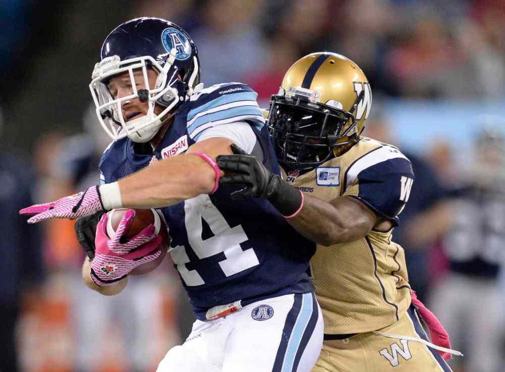 Frank Gunn / The Canadian Press
Chad Kackert of the Toronto Argonauts runs the ball as a Winnipeg Blue Bombers player defends during the first quarter of Thursday night's game in Toronto.