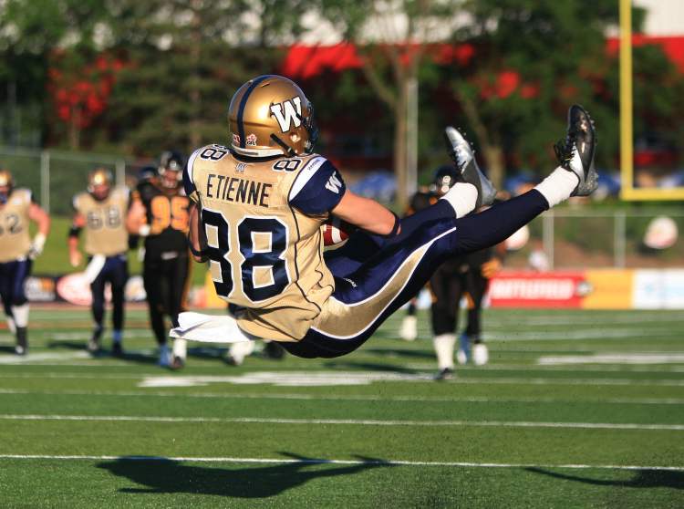 Aaron Lynett / The Canadian Press
Receiver Jade Etienne makes an acrobatic catch during first-half action on Saturday night. Other Blue Bomber highlights on offence were few and far between.