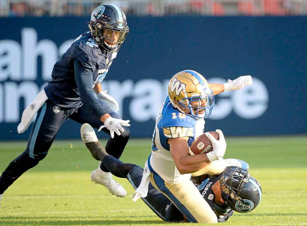 NATHAN DENETTE / THE CANADIAN PRESS
Toronto Argonauts defensive back Robert Woodson (7) looks on as Winnipeg Blue Bombers wide receiver Nic Demski (10) gets tackled by Toronto Argonauts defensive back Qudarius Ford (21) during first half.