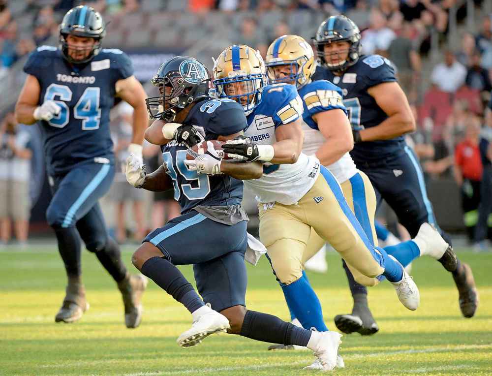 NATHAN DENETTE / THE CANADIAN PRESS
Toronto Argonauts running back Brandon Burks (35) gets a first down as he gets tackled by Winnipeg Blue Bombers linebacker Kyrie Wilson (19)during first half.