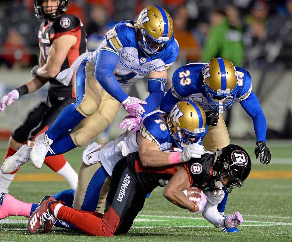 THE CANADIAN PRESS/Adrian Wyld
Winnipeg Blue Bombers defensive backs bring down Ottawa Redblacks wide receiver Diontae Spencer in Ottawa on Friday.