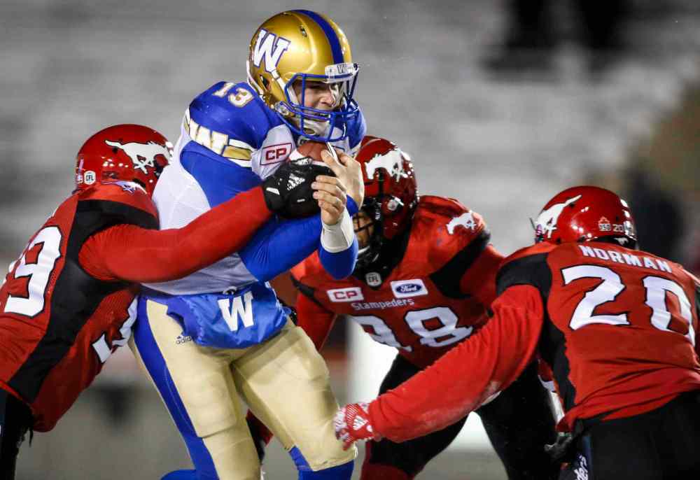 Jeff McIntosh / THE CANADIAN PRESS files
Winnipeg Blue Bombers quarterback Dan LeFevour, centre, is sacked by Calgary Stampeders during second half CFL football action in Calgary, Friday, Nov. 3. While the Bombers trounced the Stamps 23-5. Nichols was in a hotel room-turned-hospital room.