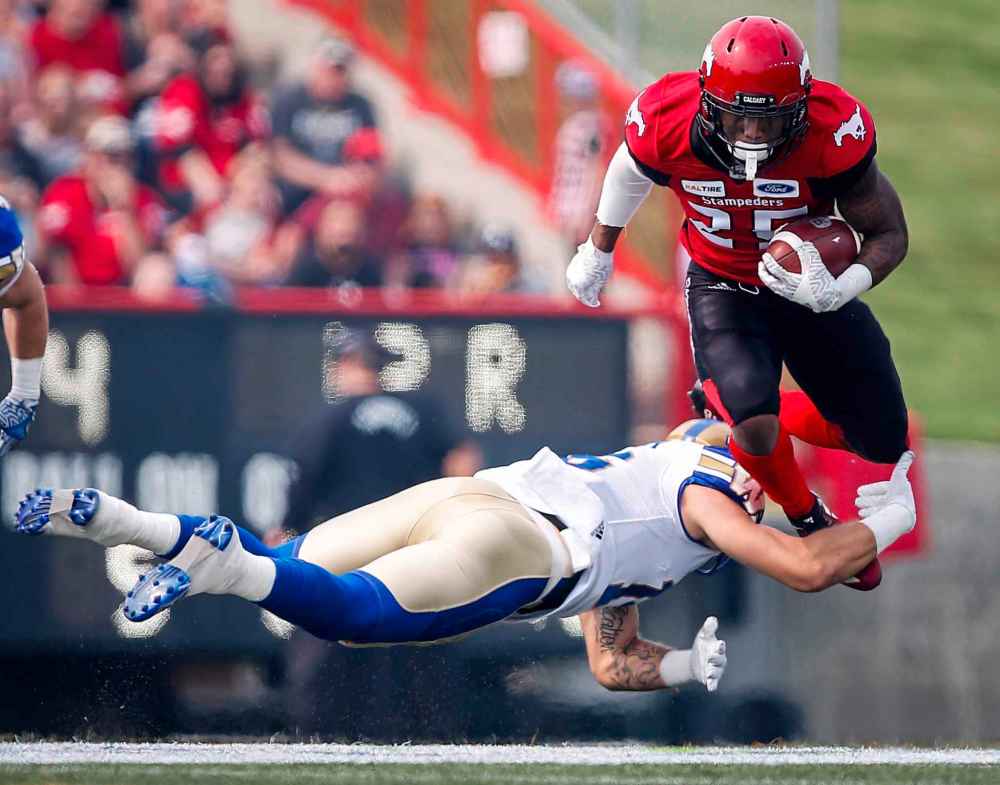 JEFF MCINTOSH / THE CANADIAN PRESS
Winnipeg Blue Bombers' Taylor Loffler, left, tackles Calgary Stampeders' Don Jackson during second quarter CFL football action in Calgary, Saturday, Aug. 25, 2018.