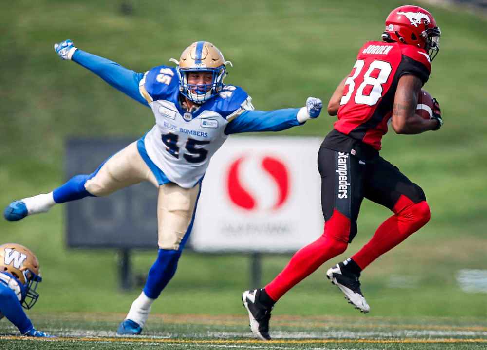 JEFF MCINTOSH / THE CANADIAN PRESS
Winnipeg Blue Bombers' Jovan Santos-Knox, left, dives for Calgary Stampeders' Kamar Jorden during first quarter CFL football action in Calgary, Saturday, Aug. 25, 2018.