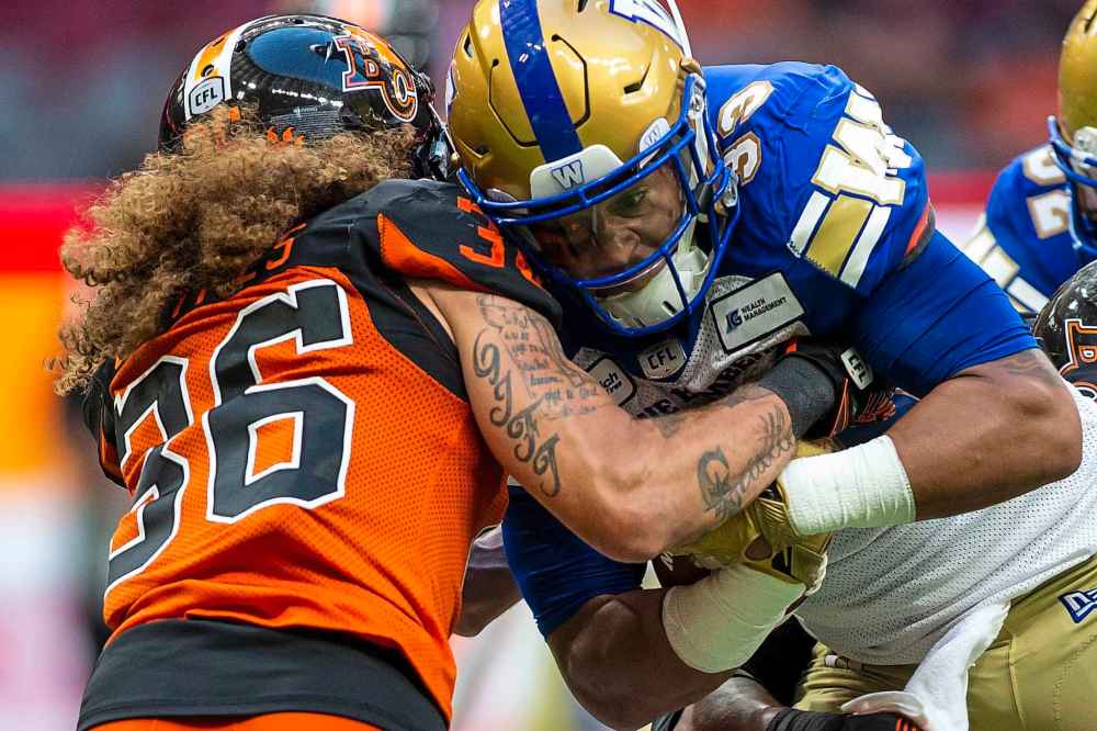 BEN NELMS / THE CANADIAN PRESS
Winnipeg Blue Bombers running back Andrew Harris (33) is tackled by B.C. Lions' Aaron Grymes (36) during the first half.