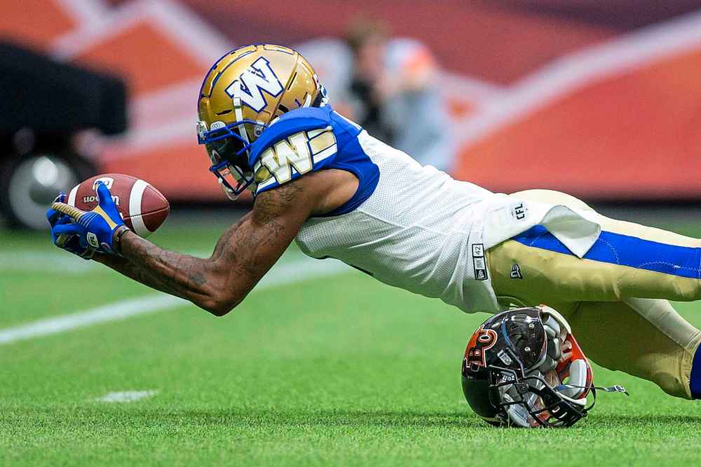 BEN NELMS / THE CANADIAN PRESS
Winnipeg Blue Bombers wide receiver Marvin Adams (1) dives with the ball after being tackled by B.C. Lions' T/J. Lee (6) during the first half.