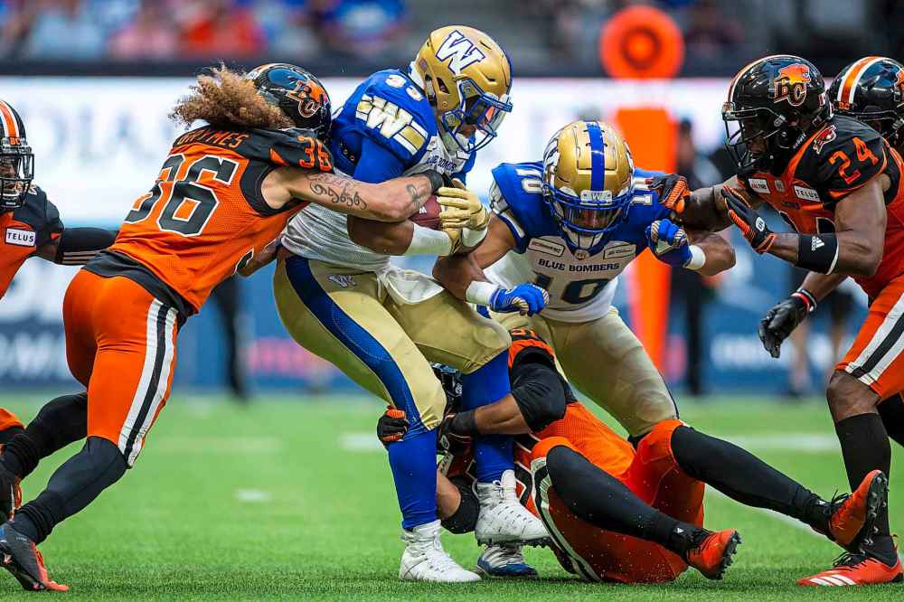 BEN NELMS / THE CANADIAN PRESS
Winnipeg Blue Bombers running back Andrew Harris (33) is tackled by B.C. Lions defensive back Aaron Grymes (36)during the first half.