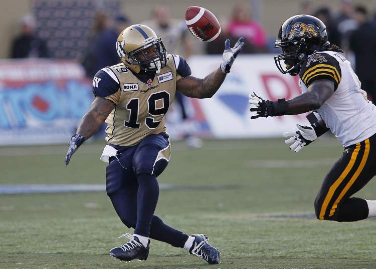 John Woods / THE CANADIAN PRESS
FILE - Winnipeg Blue Bombers' Chris Garrett bobbles a pass as Hamilton Tiger-Cats' Renauld Willams moves in during the first half of their pre-season CFL game in Winnipeg Wednesday, June 20, 2012.