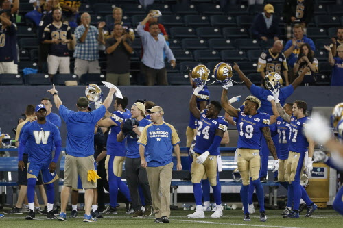CP
Blue Bombers head coach Mike O'Shea and some of his players thank the remaining fans at the end of their CFL game against the Hamilton Tiger-Cats in Winnipeg Wednesday. The game was rain and lightning delayed and ended at 12:50 a.m. (John Woods / The Canadian Press)