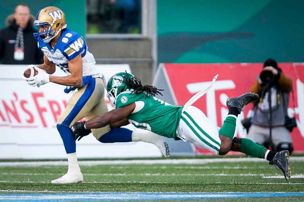 JEFF MCINTOSH / THE CANADIAN PRESS
Winnipeg Blue Bombers' Kenny Lawler, is grabbed by Saskatchewan Roughriders' Solomon Elimimian.