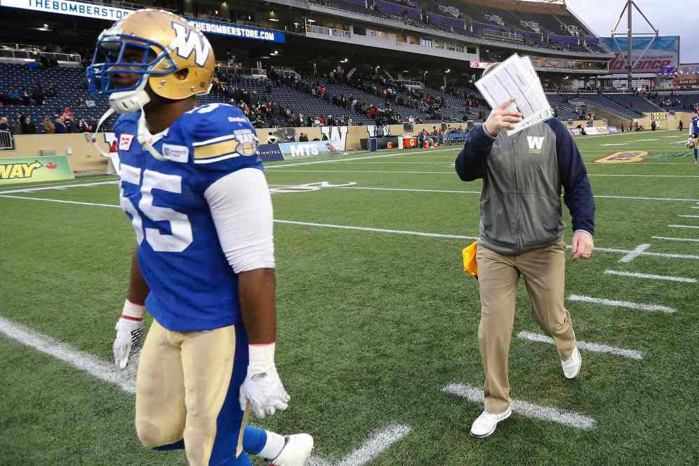 THE CANADIAN PRESS/John Woods
Winnipeg Blue Bombers head coach Mike O'Shea covers his face as he and Jamaal Westerman (55) walk off the field after the Ottawa Redblacks defeated them in CFL action in Winnipeg Saturday.