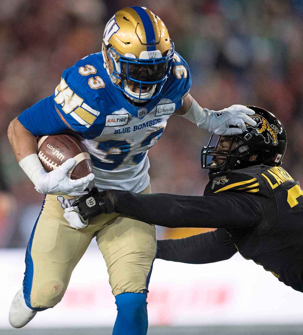 THE CANADIAN PRESS/Nathan Denette
Andrew Harris pushes off Hamilton Tiger-Cats' Simoni Lawrence during the first half in the Grey Cup game, Sunday. Harris had 18 carries for 134 yards, setting a new franchise record for most rushing yards in a Grey Cup game.