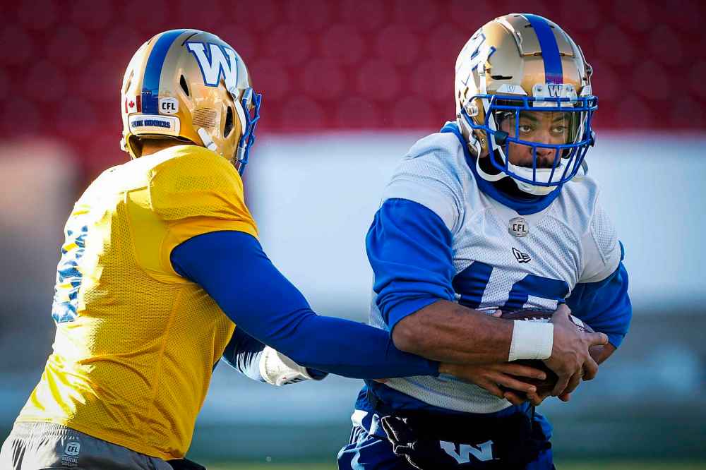 THE CANADIAN PRESS/Jeff McIntosh
Winnipeg Blue Bombers quarterback Zach Collaros, left, hands the ball off to Nic Demski during practice in Calgary, Friday. Demski summarized his thoughts on a Grey Cup win on Sunday: 