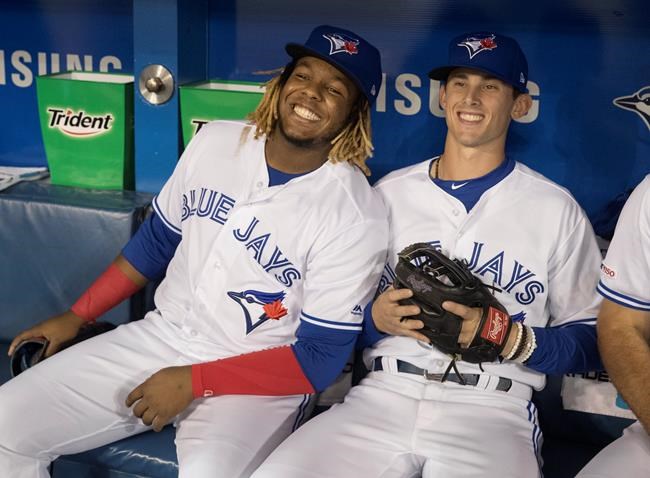 Toronto Blue Jays rookie Cavan Biggio, right, with teammate Vladimir Guerrero Jr. smile prior to the start of their Interleague MLB baseball game against the Sand Diego Padres in Toronto Friday May 24, 2019. THE CANADIAN PRESS/Fred Thornhill