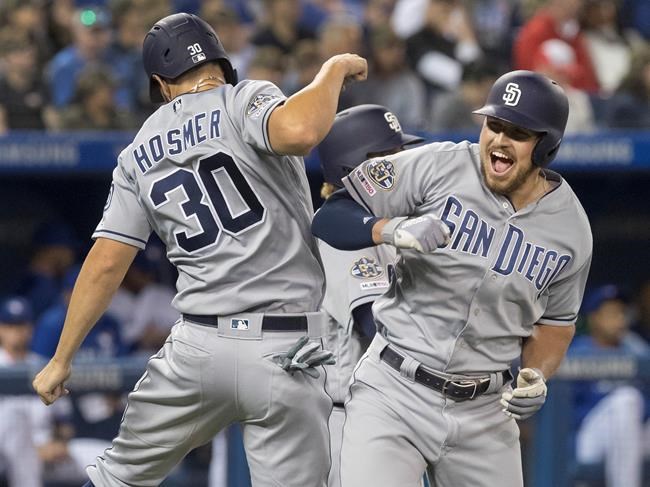 San Diego Padres' Hunter Renfroe celebrates with teammate Eric Hosmer after he hit a three run home run against the Toronto Blue Jays in the eighth inning of their Interleague MLB baseball game in Toronto Friday May 24, 2019. THE CANADIAN PRESS/Fred Thornhill