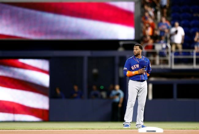New York Mets' Dominic Smith stands in the outfield during the national anthem before a baseball game against the Miami Marlins, Saturday, July 13, 2019, in Miami. (AP Photo/Brynn Anderson)