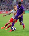 Orlando City's Ruan (2) pushes the ball away from New York Red Bulls' Daniel Royer, left, during the first half of an MLS soccer match, Sunday, July 21, 2019, in Orlando, Fla. (AP Photo/John Raoux)