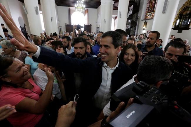 Opposition National Assembly leader Juan Guaido, who declared himself interim president, greets supporters as he arrives to attend Mass at a church in Caracas, Venezuela, Sunday, Jan. 27, 2019. Guaido says he is acting in accordance with two articles of the constitution that give the National Assembly president the right to hold power temporarily and call new elections. (AP Photo/Fernando Llano)