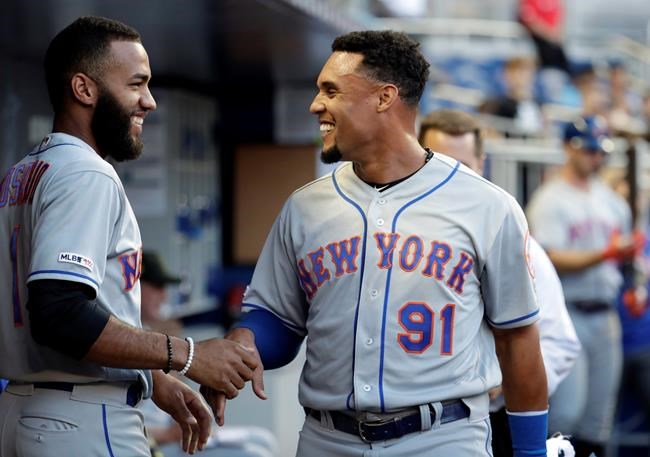 New York Mets right fielder Carlos Gomez (91) talks with shortstop Amed Rosario before the team's baseball game against the Miami Marlins, Friday, May 17, 2019, in Miami. (AP Photo/Lynne Sladky)