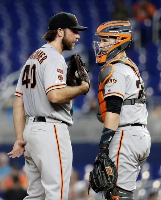 San Francisco Giants starting pitcher Madison Bumgarner (40) talks with catcher Buster Posey during the third inning of the team's baseball game against the Miami Marlins, Wednesday, May 29, 2019, in Miami. (AP Photo/Lynne Sladky)