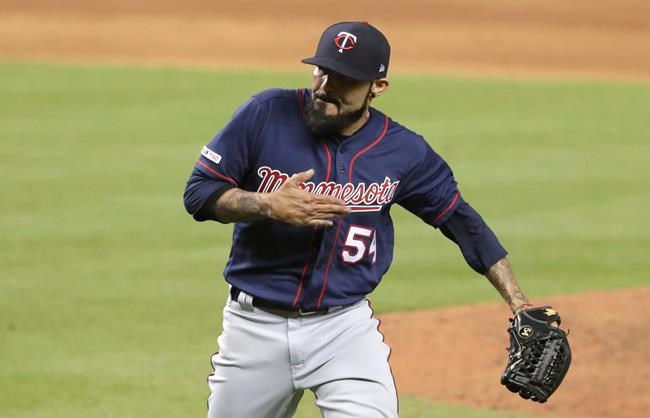 Minnesota Twins relief pitcher Sergio Romo puts his hand to his chest after Miami Marlins' Martin Prado struck out swinging during the eighth inning of a baseball game Tuesday, July 30, 2019, in Miami. The Twins won 2-1. (AP Photo/Lynne Sladky)