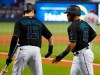 Miami Marlins' Harold Ramirez (47) is congratulated by Brian Anderson (15) after Ramirez scored on a single by Garrett Cooper during the first inning of a baseball game against the Philadelphia Phillies, Saturday, June 29, 2019, in Miami. (AP Photo/Wilfredo Lee)