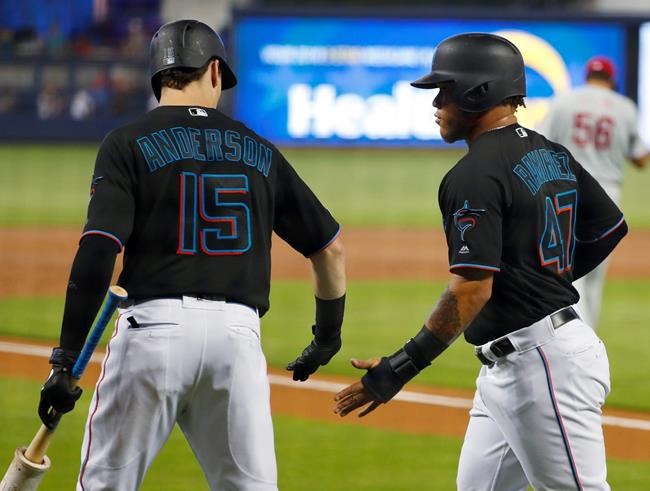 Miami Marlins' Harold Ramirez (47) is congratulated by Brian Anderson (15) after Ramirez scored on a single by Garrett Cooper during the first inning of a baseball game against the Philadelphia Phillies, Saturday, June 29, 2019, in Miami. (AP Photo/Wilfredo Lee)