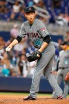Arizona Diamondbacks reliever Yoshihisa Hirano, of Japan, looks back to first base to check a runner before pitching during the ninth inning of a baseball game against the Miami Marlins, Friday, July 26, 2019, in Miami. (AP Photo/Wilfredo Lee)