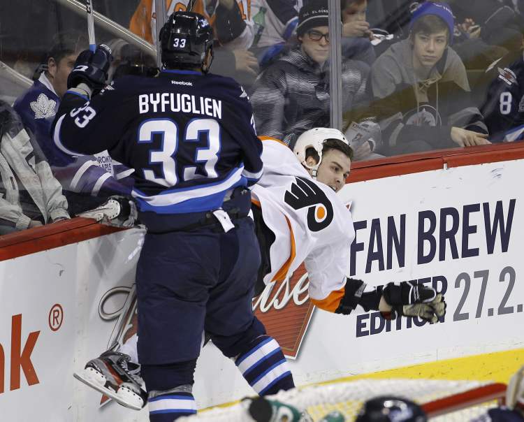 CP
Winnipeg Jets' Dustin Byfuglien (33) crushes Philadelphia Flyers' Zac Rinaldo (36) into the boards during second-period NHL hockey action in Winnipeg on Tuesday.