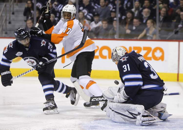 Trevor Hagan / CP
Winnipeg Jets' goaltender Ondrej Pavelec (31) makes a save as Jets' Johnny Oduya (29) and Philadelphia Flyers' Wayne Simmonds (17) battle in front of the net during first-period NHL hockey action at the MTS Centre on Tuesday. The Flyers went on to win 5-4 in overtime.