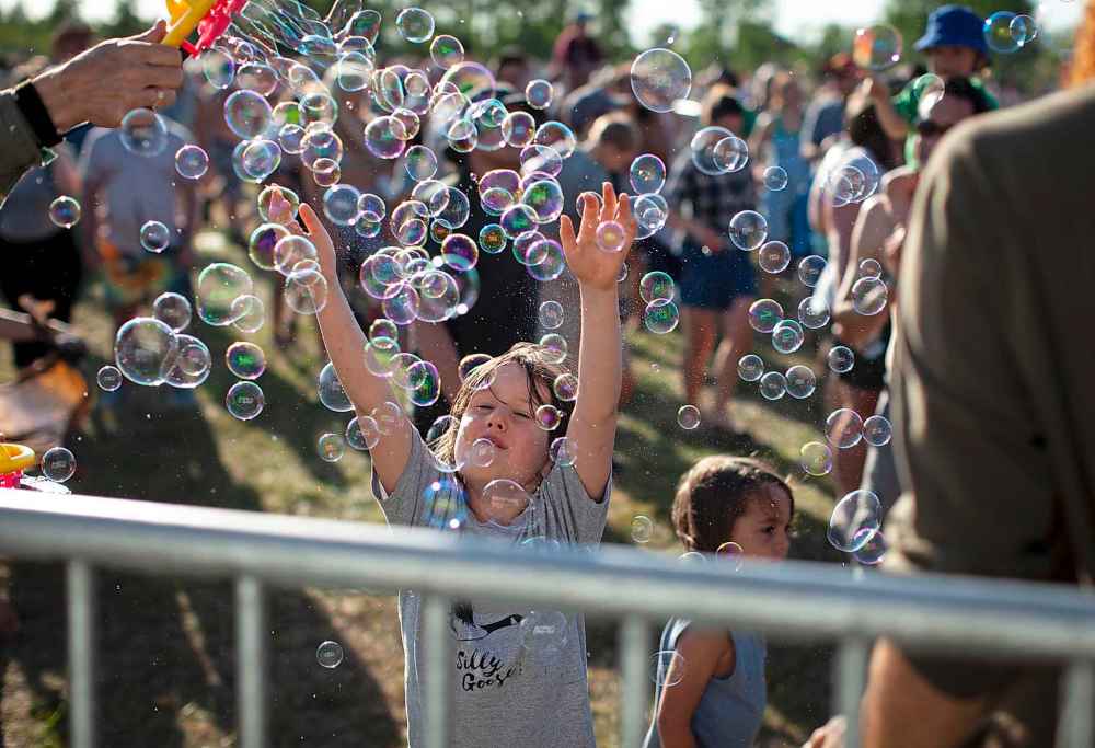 ANDREW RYAN / WINNIPEG FREE PRESS
A child enjoys a flurry of bubbles at the front row of the main stage of Folk Fest, Friday.
