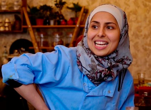In this Nov. 9, 2018 photo Malakeh Jazmati smiles in her restaurant in Berlin, Germany. After fleeing her homeland‚Äôs civil war, Jazmati reinvented herself in Jordan as a TV chef and became known as the ‚Äúqueen of cooking‚Äù to fellow Syrian refugees. Now in Berlin she‚Äôs starting over again, opening a restaurant she hopes can serve as ‚Äúmedicine against homesickness‚Äù for the thousands of newly-arrived Syrians in the German capital. (AP Photo/Jona Kallgren)
