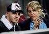 FILE - In this Thursday, Feb. 21, 2019, Inter Milan's Mauro Icardi is flanked by his wife Wanda Nara as they sit in the stands during the Europa League, round of 32, second leg soccer match between Inter Milan and SK Rapid Vienna, at the San Siro stadium in Milan, Italy. Mauro Icardi has resumed training with his Inter Milan teammates, ending a six-week exile. Icardi has not been on the field in more than a month, since being stripped off his captaincy amid protracted contract negotiations. The Argentine forward has now ended treatment and resumed training on Thursday, with those that had not been called up for international duty. Icardi could be called up for Inter‚Äôs next match, at home to Lazio in Serie A on March 31. (AP Photo/Luca Bruno, File)