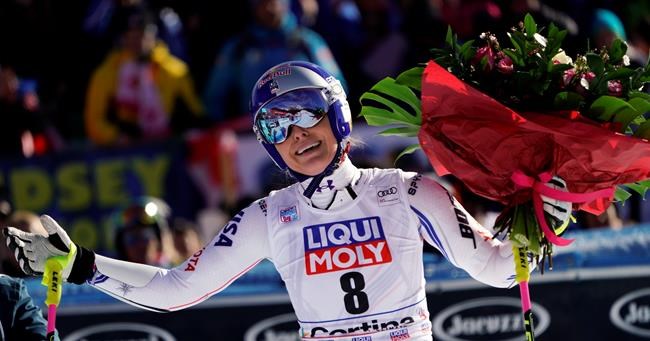FILE - In this Sunday, Jan. 20, 2019 filer, United States' Lindsey Vonn holds a bunch of flowers after completing an alpine ski, women's World Cup super-G in Cortina D'Ampezzo, Italy. It seemed like destiny played a role on Sunday when Mikaela Shiffrin won what could very well turn out to be Lindsey Vonn's last race. Vonn broke down emotionally after she failed to finish a World Cup super-G on knees so worn down that she describes them as