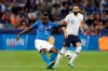 FILE - In this Friday, June 1, 2018 file photo, Italy's Mario Balotelli, left, kicks the ball while France's Edil Rami looks on during a friendly soccer match between France and Italy at the Allianz Riviera stadium in Nice, southern France. Italy coach Roberto Mancini has set the bar high for Mario Balotelli’s chances of returning to the national team. Balotelli recently returned to Serie A with Brescia, his hometown club, but his season hasn’t started yet as he serves a four-match ban following a straight red card in his final game for Marseille against Montpellier in May. (AP Photo/Claude Paris, File)