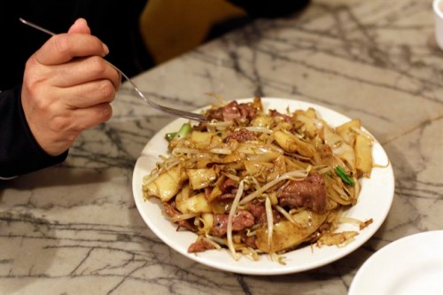 A woman begins to eat a dish of beef chow fun for lunch at the Sam Wo restaurant in Chinatown in San Francisco, Friday, April 20, 2012. The 100-year-old Chinese restaurant known for having 
