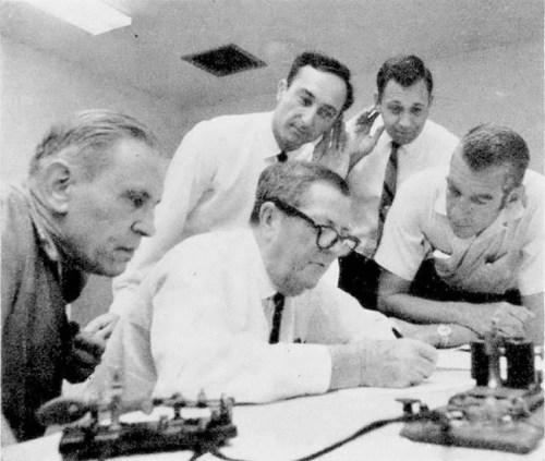 FILE - In this May 10, 1969, file photo, Associated Press White House correspondents Doug Cornell, left, and Frank Cormier, right, watch as Western Union officials receive a direct wire Morse message in Miami from Promontory, Utah. The message was a duplicate of the one sent 100 years earlier after the completion of the first railroad transcontinental link. Another message was sent to President Nixon nearby in Key Biscayne, Fla., like the one sent to President Grant 100 years earlier. (AP Photo, File)