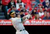 FILE - In this Sept. 29, 2018, file photo, Oakland Athletics' Khris Davis follows through on his two-run home run against the Los Angeles Angels during the first inning of a baseball game, in Anaheim, Calif. Davis led the majors in home runs, led the Oakland Athletics back to the playoffs for the first time in four years, then received a $6 million raise this offseason for a 2019 salary of $16.5 million. (AP Photo/Marcio Jose Sanchez, File)