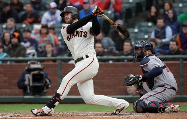 San Francisco Giants' Evan Longoria watches his RBI double in front of Atlanta Braves catcher Brian McCann during the first inning of a baseball game in San Francisco, Tuesday, May 21, 2019. (AP Photo/Jeff Chiu)