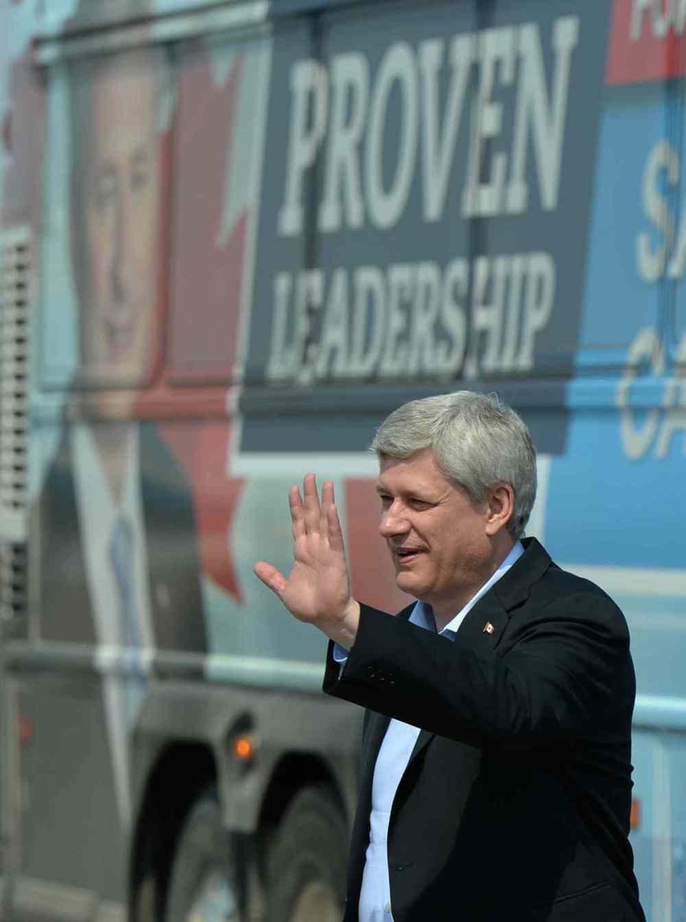 Conservative Leader Stephen Harper waves as he makes his way to the airplane as he departs Regina on Thursday, August 13, 2015. (Sean Kilpatrick / The Canadian Press)