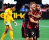Atlanta United midfielder Julian Gressel, center, celebrates his apparent goal past Orlando City goalkeeper Brian Rowe,left, with Josef Martinez, right, during the second half in a MLS soccer match on Sunday, May 12, 2019, in Atlanta. The goal was taken off the board after review, but Atlanta United held on to win the game 1-0. (Curtis Compton/Atlanta Journal-Constitution via AP)