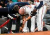 Atlanta Braves catcher Brian McCann is tended to by trainer Mike Frostad, left, after being thrown out sliding into third base by Miami Marlins catcher Jorge Alfaro on a bunt by Kyle Wright during the fifth inning of a baseball game against the Miami Marlins, Saturday, April 6, 2019, in Atlanta. (AP Photo/John Amis)
