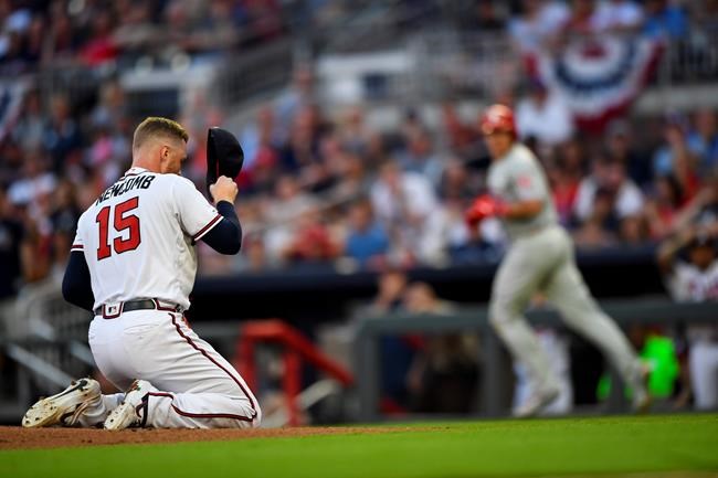 Atlanta Braves pitcher Sean Newcomb (15) goes to his knees after being hit in the head with a line drive by Philadelphia Phillies' J.T. Realmuto, right, as Realmuto makes his way to base on a ground-rule double and injury delay during the third inning of a baseball game Saturday, June 15, 2019, in Atlanta. Newcombe came out of the game. (AP Photo/John Amis)