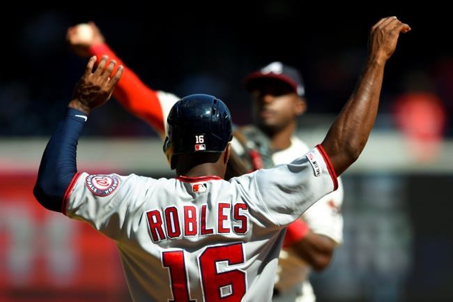 Washington Nationals' Victor Robles (16) is out at second base as Atlanta Braves second baseman Adeiny Hechavarria turns a double play against Yan Gomes at first base during the eighth inning of a baseball game Sunday, Sept. 8, 2019, in Atlanta. (AP Photo/John Amis)