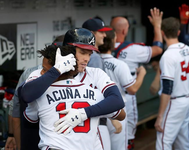 Atlanta Braves' Freddie Freeman (5) embraces teammate Ronald Acuna Jr., (13) after hitting a two-run home run in the first inning of a baseball game against the New York Mets Wednesday, June 19, 2019, in Atlanta. (AP Photo/John Bazemore)
