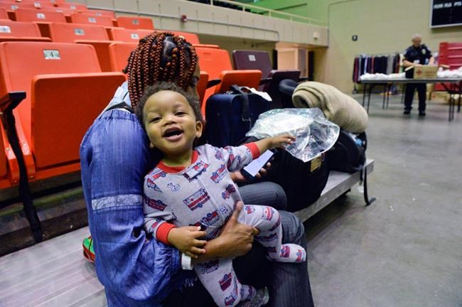 Marilyn Legree holds her son Almighty as take shelter in Savannah's Civic Center prior to the potential arrival of Hurricane Dorian, Wednesday, Sept. 4, 2019, in Savannah, Ga. She said her residence is in a flood zone and decided to weather the storm at the Civic Center. (Steve Bisson/Savannah Morning News via AP)